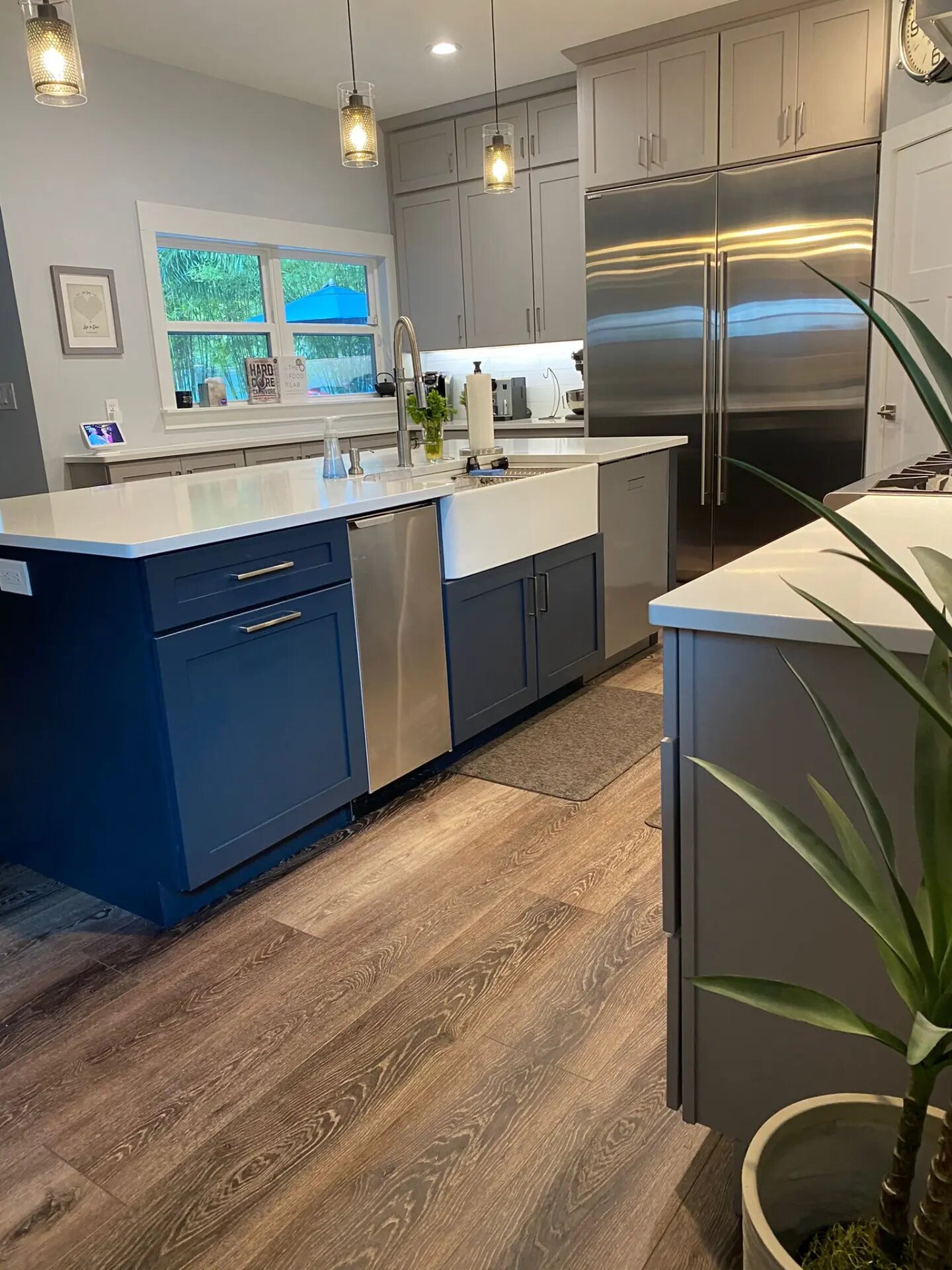 Navy kitchen island with a white quartz countertop and apron sink, fabricated and installed by Dreamstone Surfaces